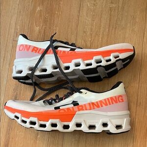 On Running White and Orange Athletic Shoes